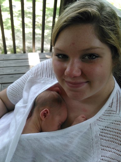 Woman holding baby against chest